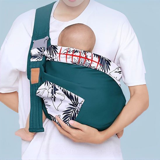 Parent attentif avec bébé blotti dans son écharpe florale