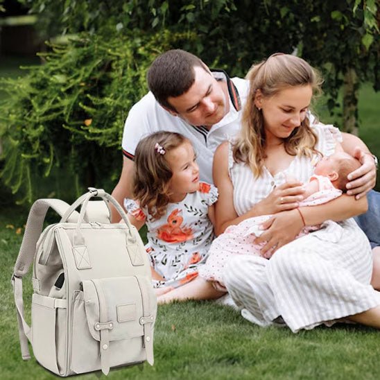 père avec sa famille et sac à dos à langer
