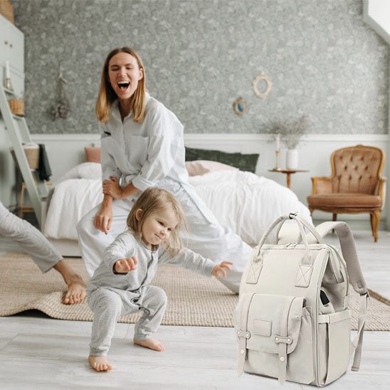 mère fille au sports et sac à dos à langer