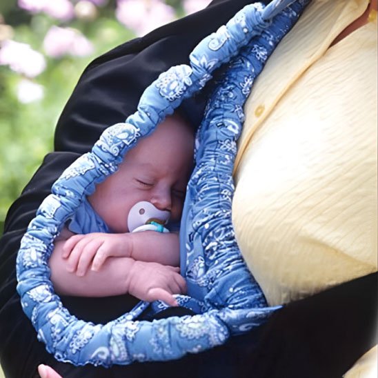 Extérieur fleuri avec bébé paisiblement installé contre le torse du parent
