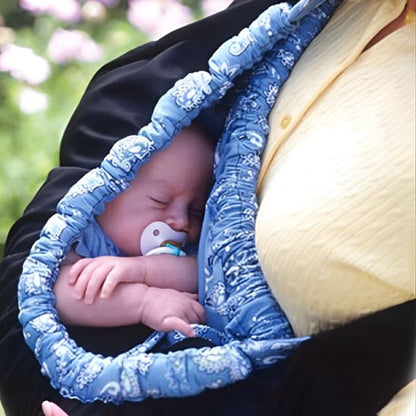 Extérieur fleuri avec bébé paisiblement installé contre le torse du parent