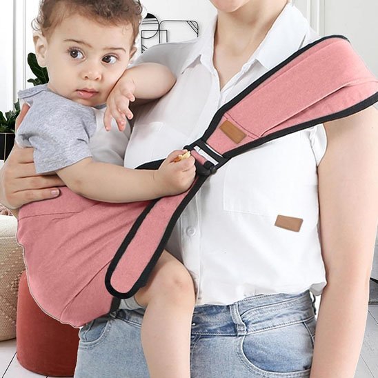 bébé la main sur sa joue dans son porte bébé