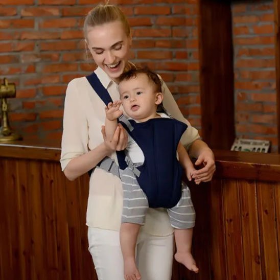 bébé lève son bras dans son porte bébé