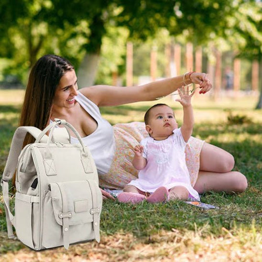 maman allongée avec bébé et sac à dos à langer des arbres