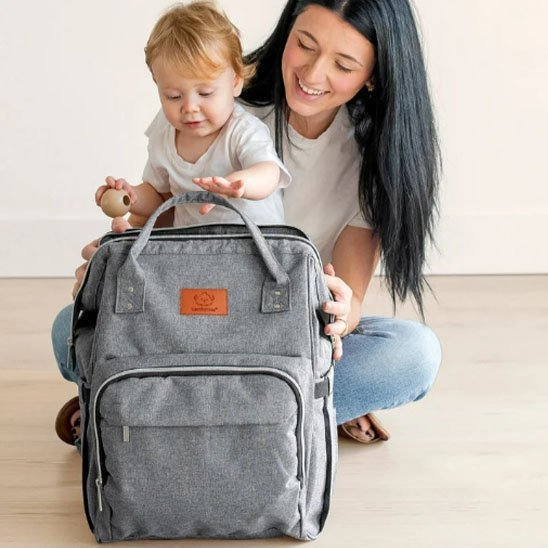 mère et fille et sac a langer gris clair mur blanc