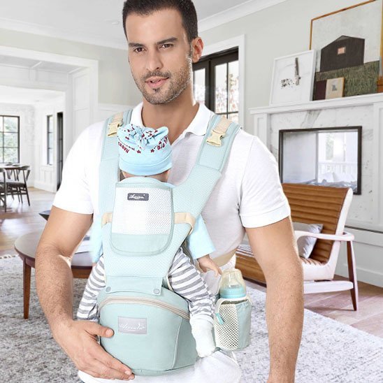 un nourrisson avec papa dans porte bebe
