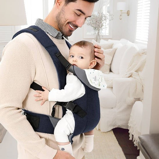papa souriant avec bébé dans son porte bébé
