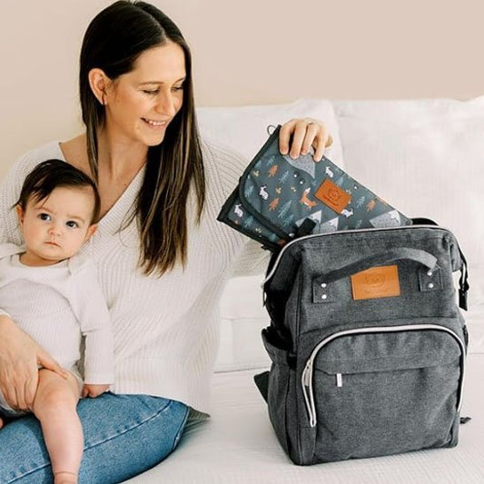 maman sa fille au genou et son sac a langer gris